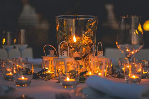 clear drinking glass with lighted candles on table