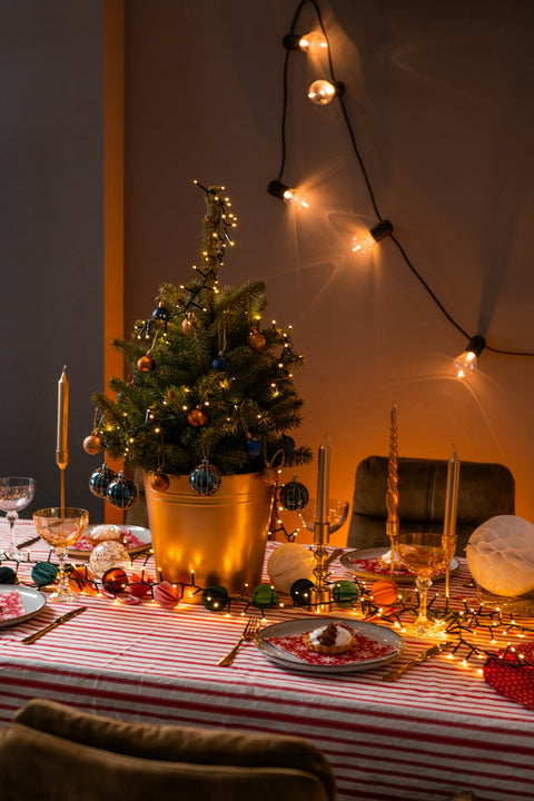 a table with a christmas tree and plates and glasses on it